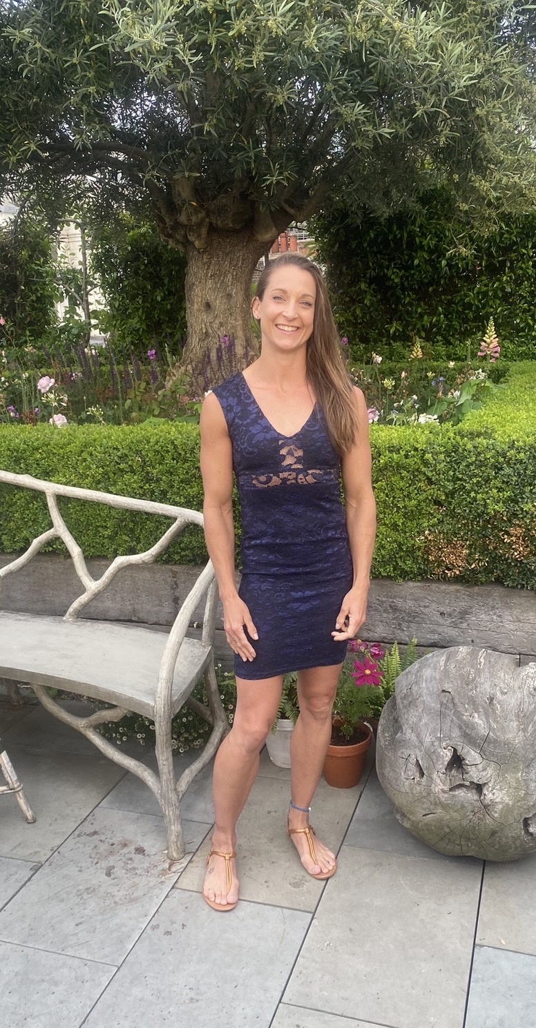 Liz Marsland in a navy lace dress in a garden